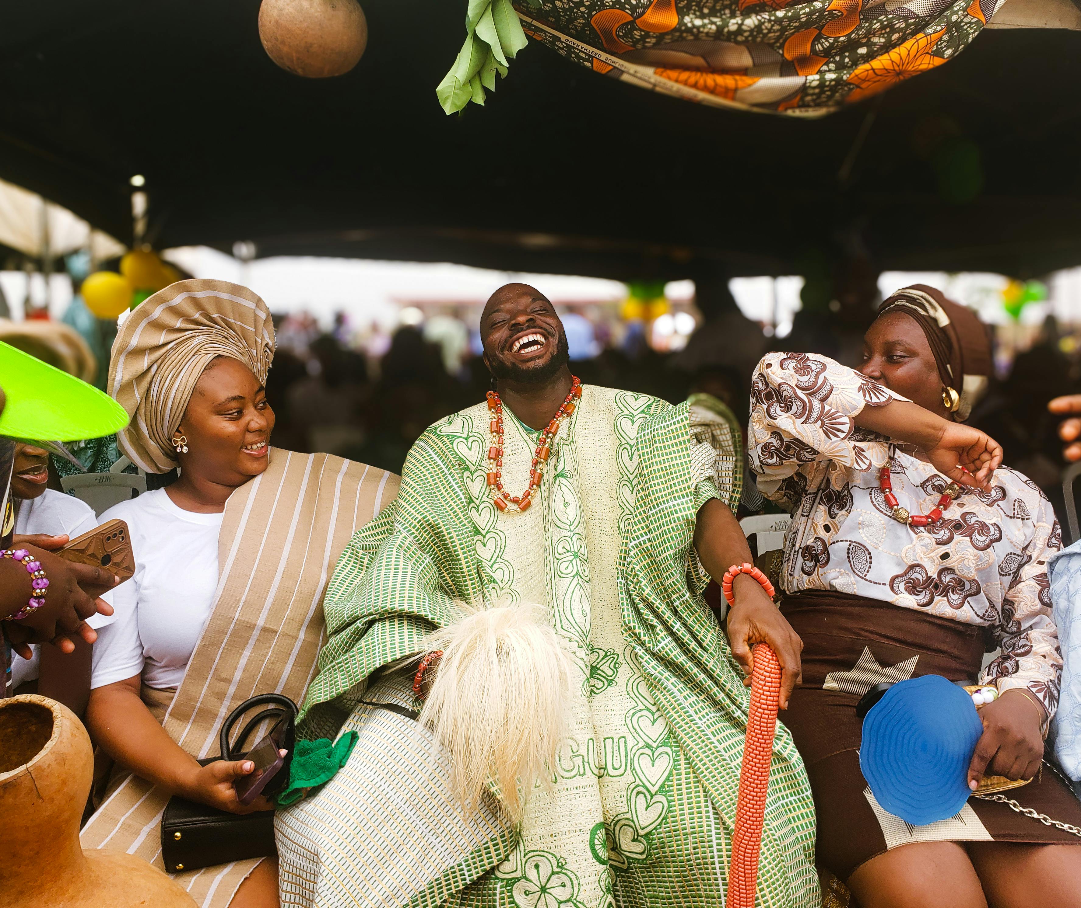 African Drama: Vibrant scene of Nigerians in traditional attire sharing joy at a cultural festival