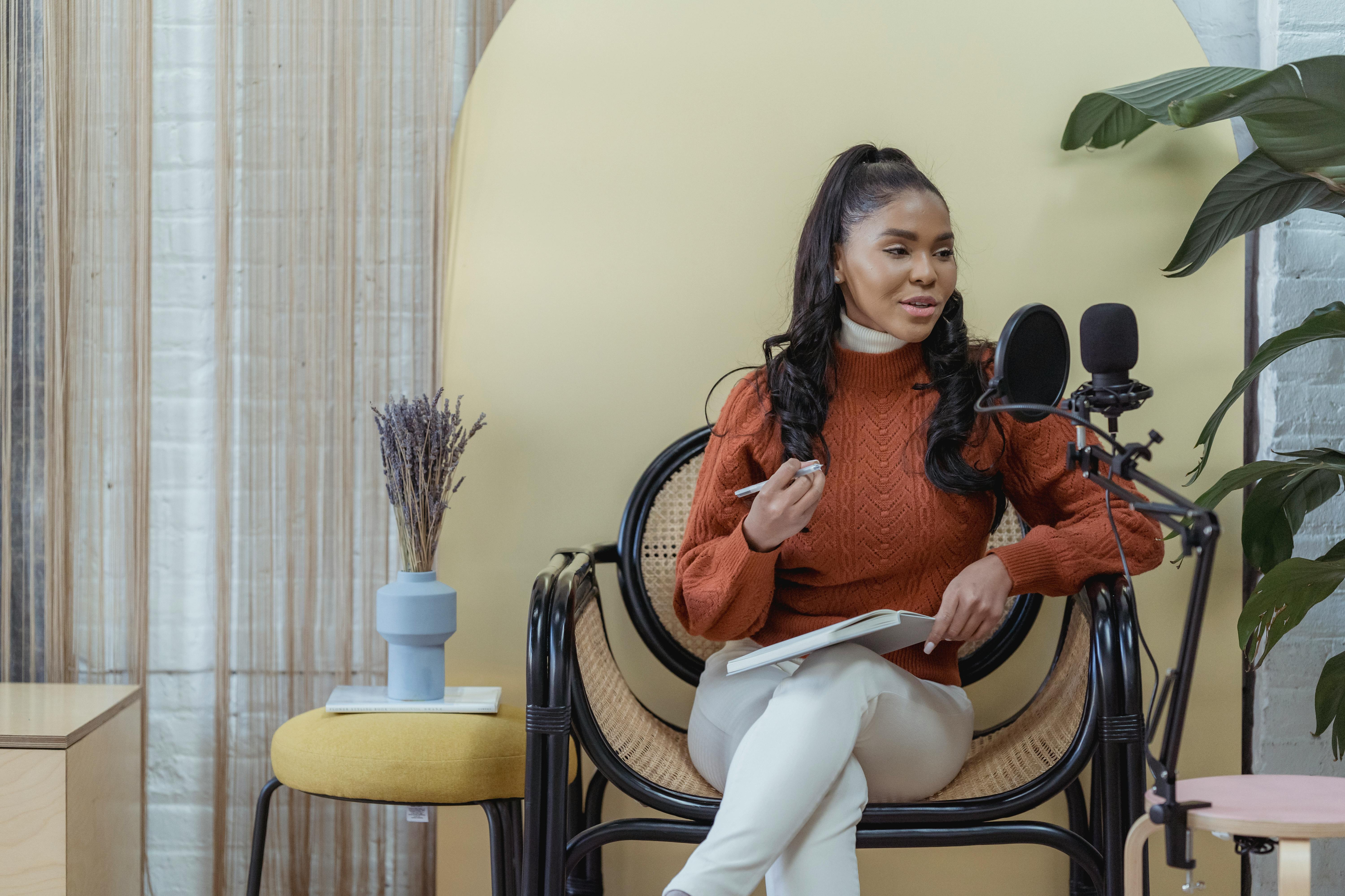 Professional woman hosting a podcast in a stylish indoor studio setting, conveying creativity and positivity.